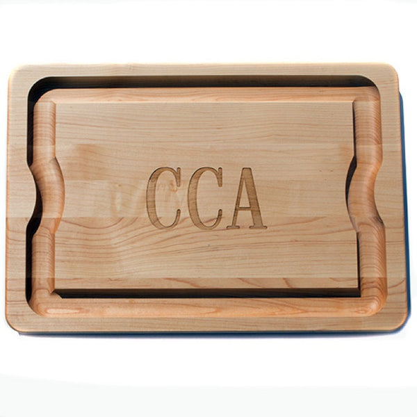 maple wood cutting board with monogram in center letters 'CCA'